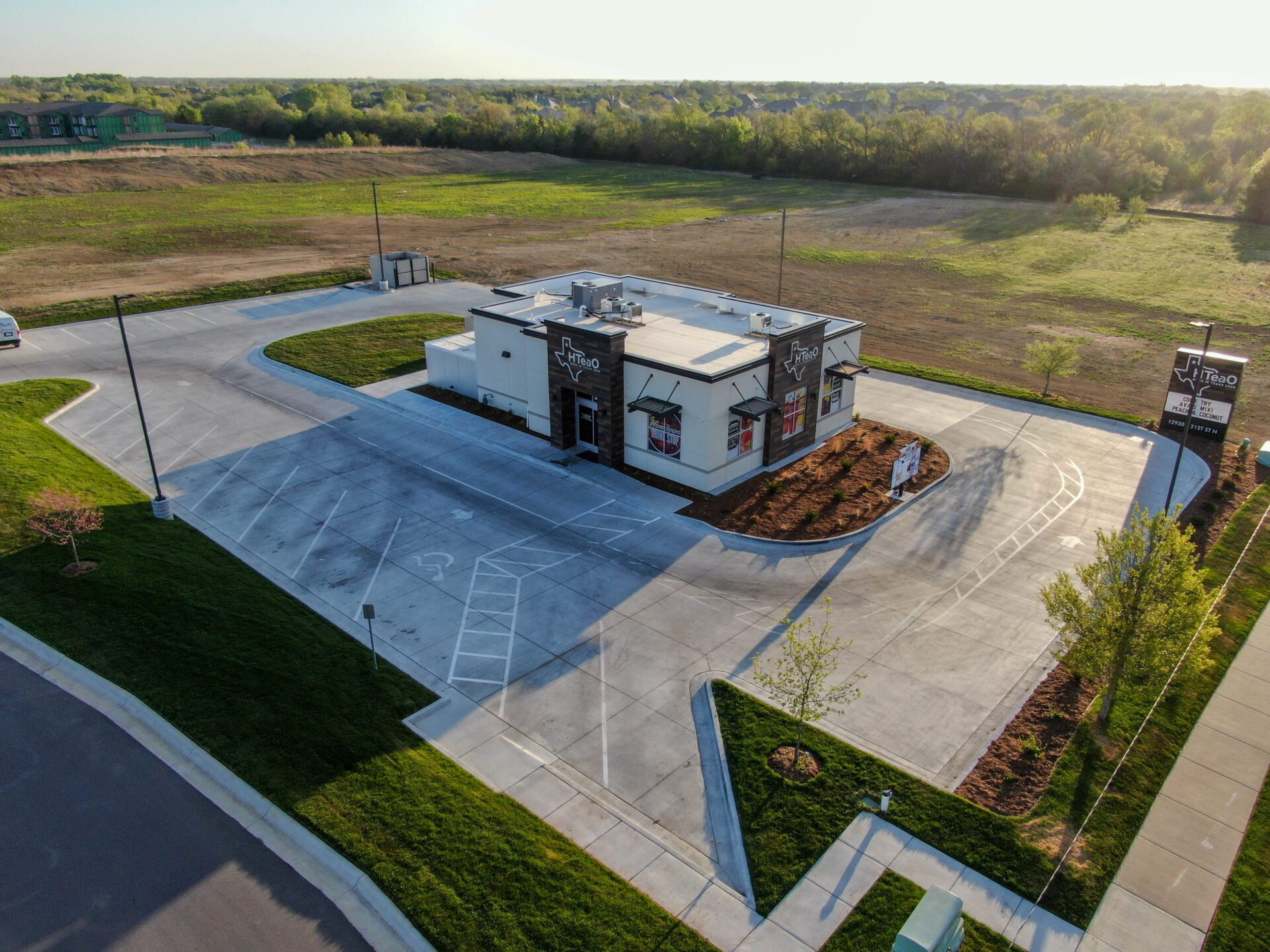 Exterior drone shot of the building, includes the signage and parking lot.