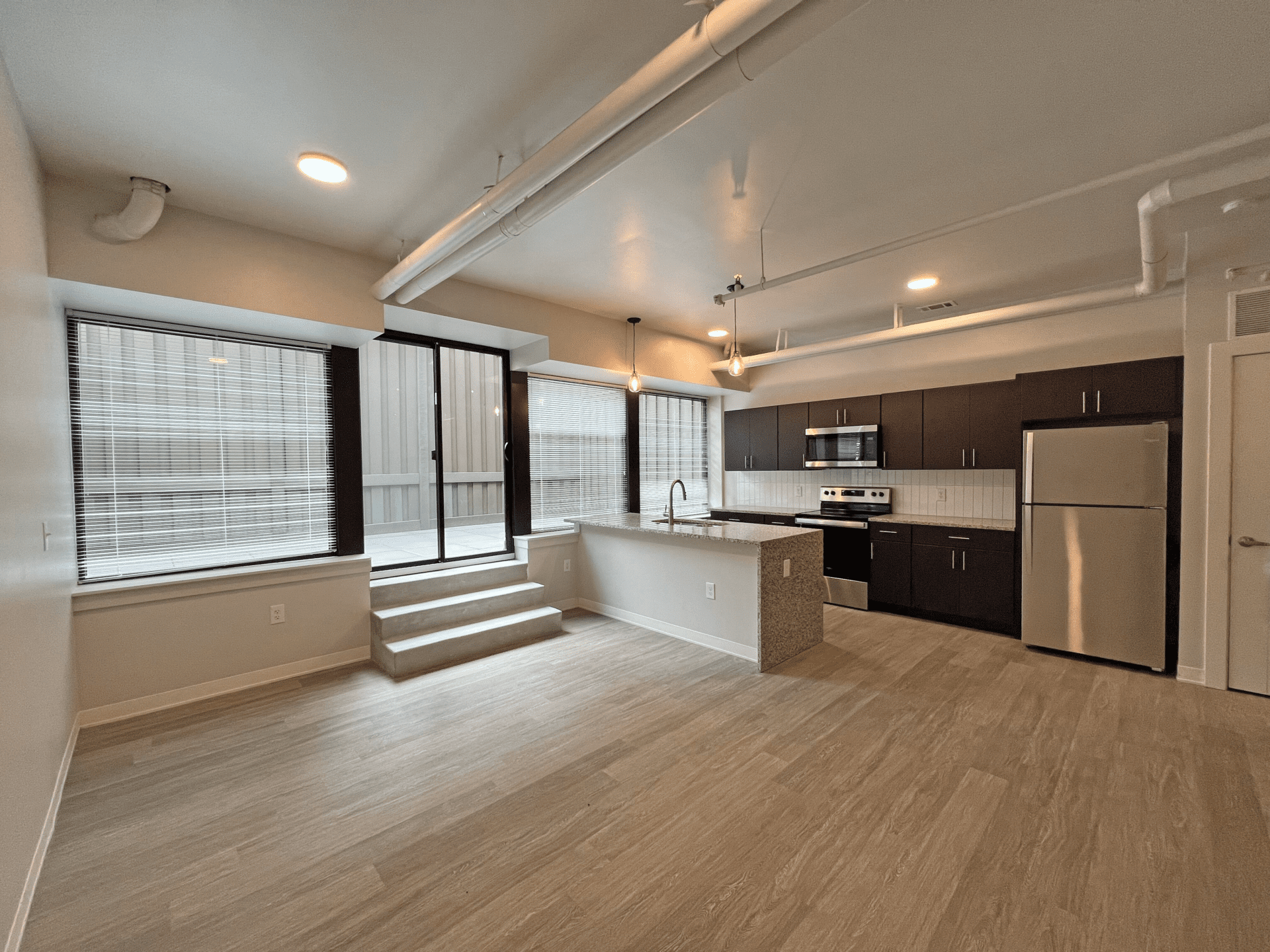 Open floor plan apartment with a full wall of windows and a patio