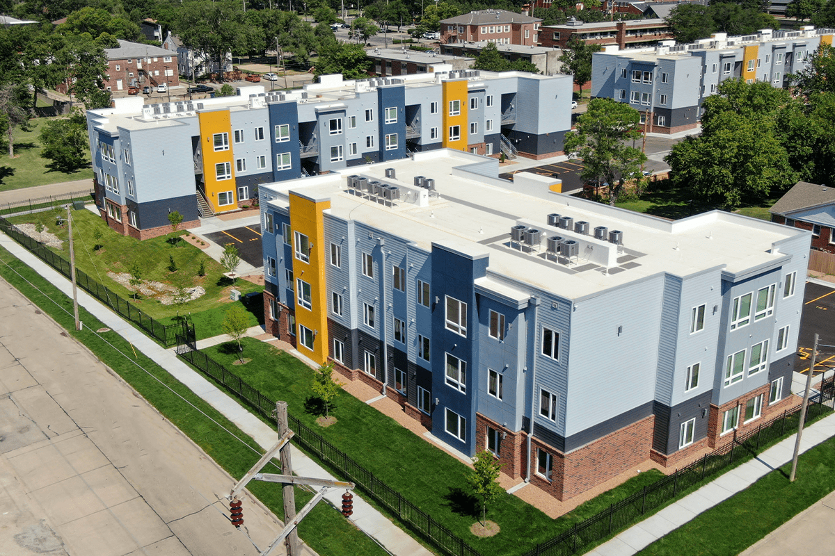 Exterior drone shot of the exterior of three, 3-story apartment buildings