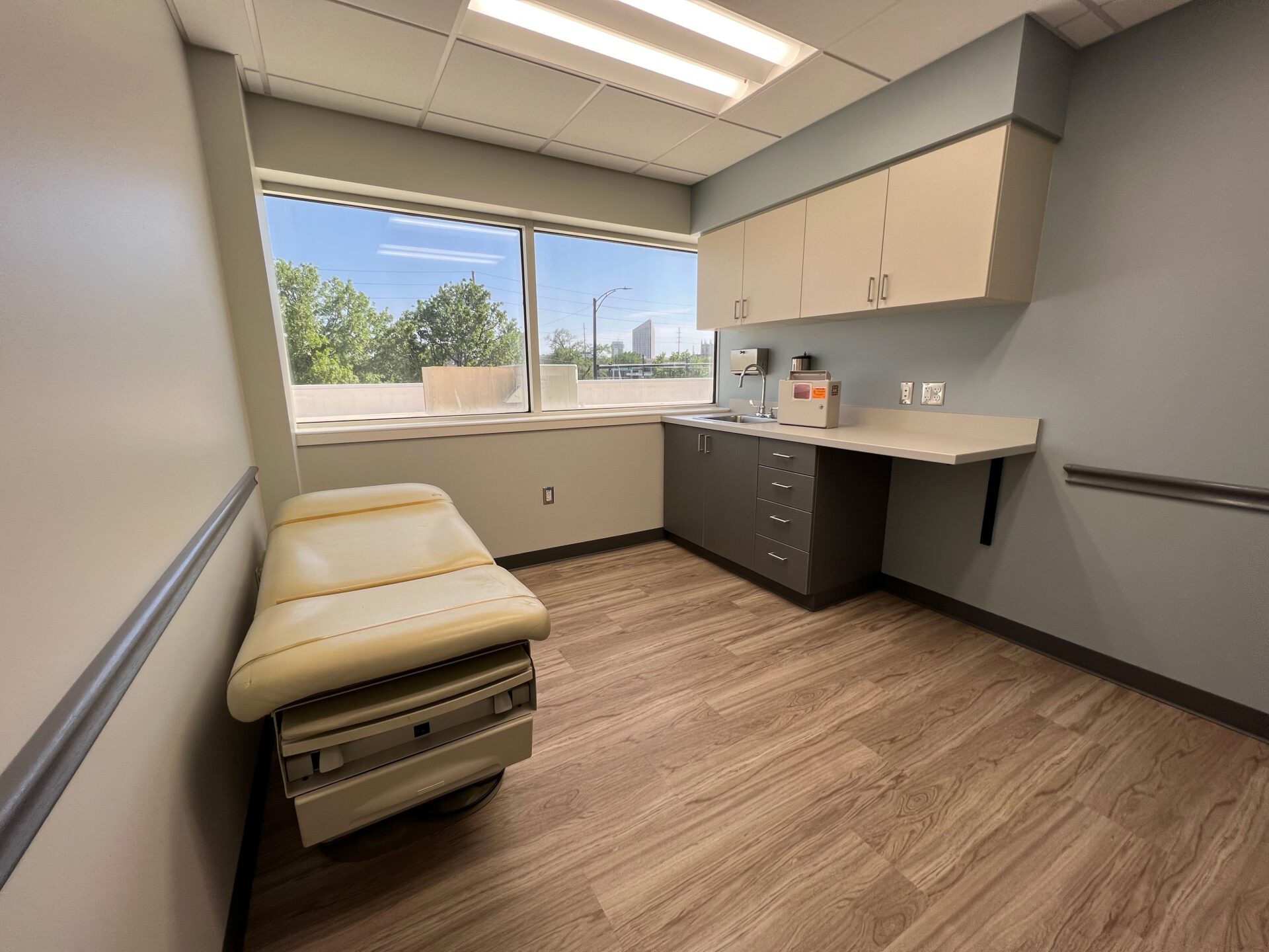 Exam room with a bed, counter space, and a sink.