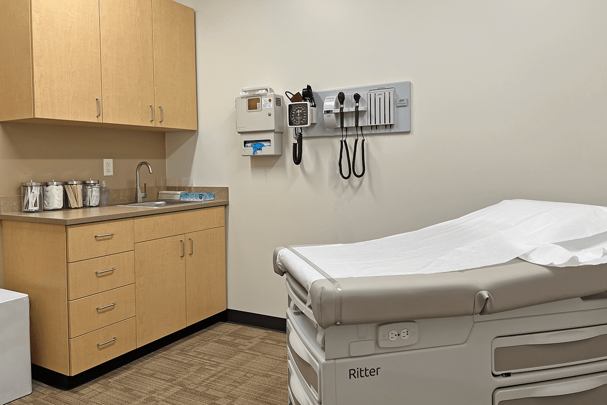 Exam room with cabinets, exam equipment, and exam table.