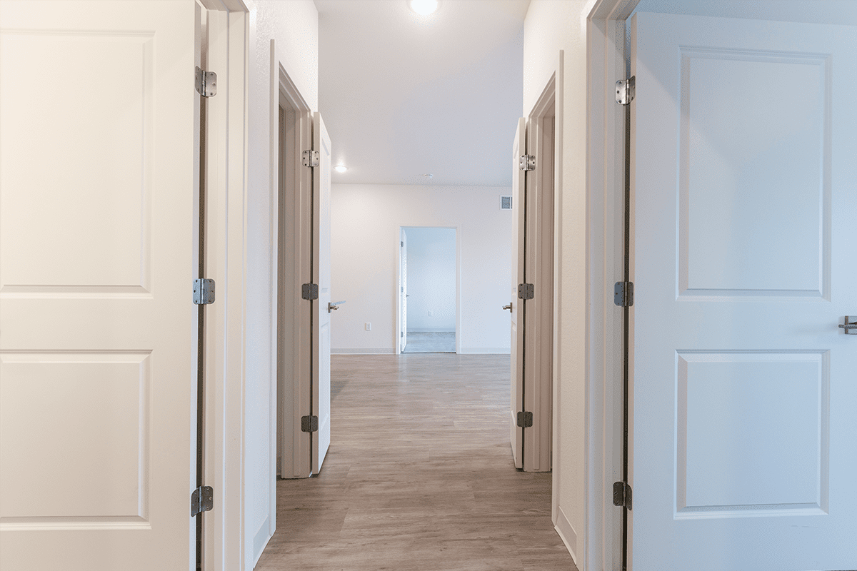 A hallway with several doors leading to different rooms.