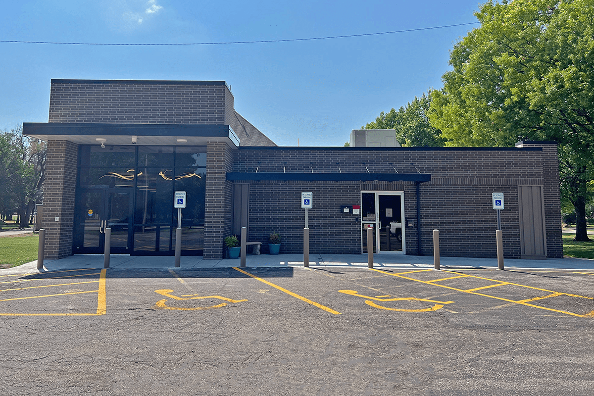 Modern one-story building with brick facade and prominent glass entrance.
